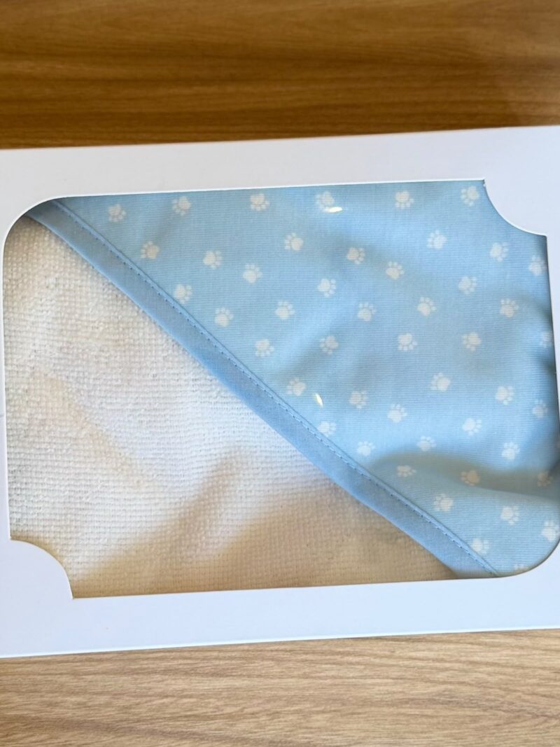 Toalla blanca con capucha azul de huellitas blancas